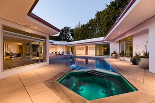 The central courtyard features a swimming pool that echoes the floor plan. 