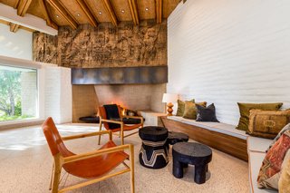 The "Brutalist-style" frieze was one of the original details preserved during the rebuild of the home. The custom walnut banquette is complete with Neutra-style trapezoidal cushions in fabric from Knoll. 
