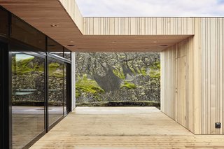 Two cedar-clad volumes are connected to the main volume via a cedar deck.