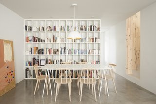 The built-in bookshelf was salvaged in the renovation, painted white, and now serves as a backdrop to the dining room area. 