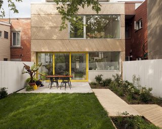 Although the home's historic front facade needed to be preserved, the back of the residence was ripe for a remodel. The architects cladded the exterior in eastern cedar. The wood is offset with large expanses of glass, as well as yellow accents to add a playful atmosphere. 