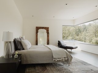 A sweeping expanse of glass spans the corner in the master suite, integrating a sense of the outdoors into the bedroom.