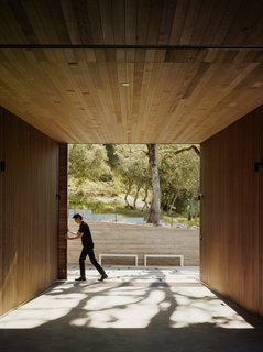 A sliding wooden door marks the entrance to the interior courtyard of the home. The residence consists of three connected volumes of different heights wrapping around the center of the podium, and the spaces inside them carefully scaled: small enough for introspection, and large enough to take in the landscape. <span style="color: rgb(204, 204, 204); font-size: 13px;">Photo by Joe Fletcher</span>