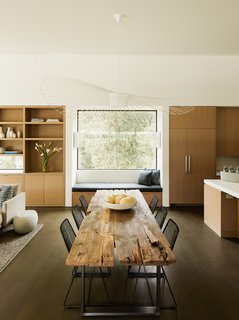 A dining area divides the open kitchen from the living room. 