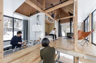 Inside, the open-plan layout features a kitchen which morphs into the living area with a raised built-in bench/reading nook, along with an upper level that overlooks the space. 