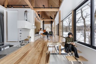 The kitchen is layered with the living room—the counter space becomes the flooring in the living area, and steps are used as additional seating. 
