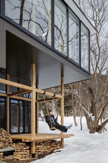 Partially enclosed, the exterior platform features an outdoor swing that is suspended from the timber-framed porch.