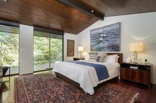 A private wing contains three bedrooms, including the master suite. A fourth bedroom is located downstairs. 