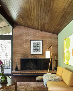 A brick, wood-burning fireplace anchors the area.