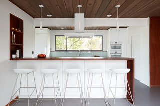 Kitchen cabinetry, countertops, appliances, and light fixtures are all white, making the kitchen feel more light and airy. The pale blue backsplash matches the shade of the Heath tiles that is in the bathroom. 