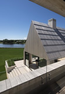 The cedar shingles—common to local buildings—are scaled up to the size of the boards to cover the roof and sidewalls. 