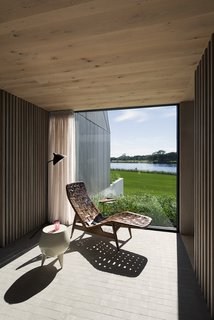 A quiet spot for contemplation takes advantage of the surrounding scenery. Cedar screens provide privacy and filter light, while also picking up on the lines of the exterior vertical siding. <br> <span style="color: rgb(204, 204, 204); font-size: 13px;">Bates Masi +Architects</span>