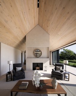 The interiors are bright and airy thanks to high wood-paneled ceilings and expansive glazing that open to the outdoors. 