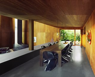 The spacious dining area overlooks the open living room and the surrounding greenery. 