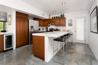 The kitchen features many upgrades, including new cabinetry, quartz countertops, stainless steel appliances, a wine fridge, and a breakfast bar. 