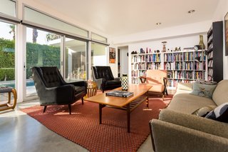 The open-plan living room has a wall of glass sliding doors and clerestory windows that trace the iconic angled roofline.