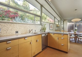 The kitchen opens to the dining area, where clerestory windows provide additional natural light. 