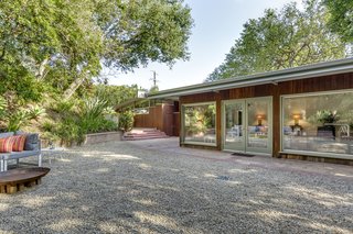 Glass walls embrace the views, and the open plan flows freely through the tall doors that open wide to the patios and private gardens on all sides.