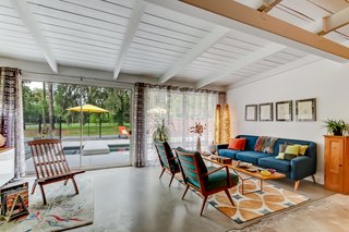 Sliding glass doors lead out from the living room to the pool deck with a built-in brick hearth. 
