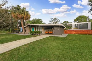 Behind the home is a detached office/library space with a corrugated iron exterior.