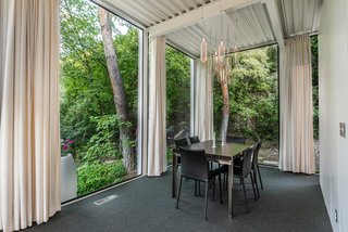 Set in a forested area, the home feels completely integrated into the surrounding nature. 