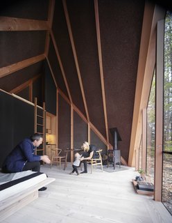 An elegant Morsøe fireplace is nestled in one corner, while off-the-grid equipment is tucked away in the back.