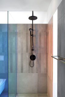 The dichroic glass displays two different colors by undergoing a color change in certain lighting conditions. The concrete tiles reference the Brutalist building. 