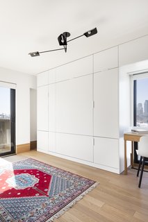 A hideaway bed in the guest room allows this space to also be used as an office. Sangaré’s UNITÉ lighting hangs above. 