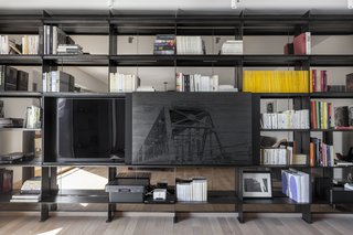 A commissioned art piece by local artist James Kennedy is mounted on a sliding door which hides the television set. 