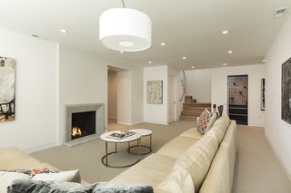 This view shows the space from another angle. The door at the bottom of the staircase leads to the laundry area. The door to the right of the staircase goes to a modern wine cellar with a sleek mounted wine rack from Stact. 
