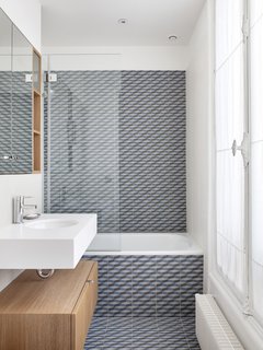 The children's bathroom features Mutina's Azulej cubo grigio tiling on the floor and walls.