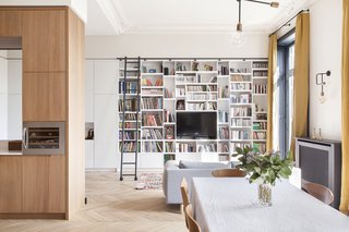 A wall of custom-designed bookshelves with a library ladder enriches the sitting area. 