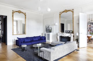 The main living room has become the central and multi-functional zone for the entire family. A Moroso Gentry sofa in royal blue, as well as a Poltrona Frau sofa and footrest have been reupholstered by Petites Mains à la carte. The lighting is FLOS AIM blanche, the coffee table is from AMPM, and the rug is from Annie Paté. 