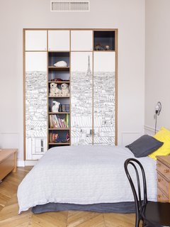 Oh My Wall Paris Wallpaper has been placed on wardrobe doors with the shelves painted off-black from Farrow & Ball. 
