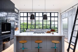 The kitchen includes top-of-the-line stainless steel appliances, custom floor-to-ceiling cabinetry, countertops in French Blue de Savoie marble, and a Pullman rolling ladder.