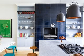 The pièce de résistance, however, is a one-of-a-kind Grillworks grill. Located in a refurbished wood-burning fireplace, it has been clad in striking tiles from Heath Ceramics and is flanked by open shelving. 