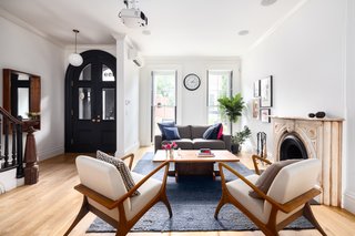 The living room also features floor-to-ceiling windows, an original marble mantle, as well as a wood-burning fireplace. 