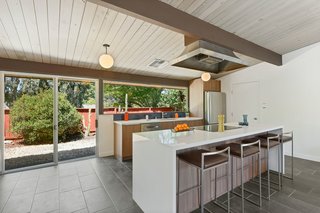 Thanks to a recent renovation, the kitchen now has an expanded breakfast island, Bosch stainless appliances, and a modern induction cooktop.
