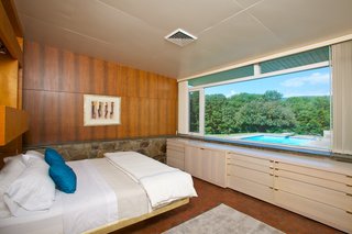 The master bedroom also overlooks the pool and the surrounding natural landscape.