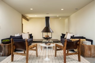 A cozy den with an original fireplace sits just off the kitchen. The fireplace, which appears in photographs taken by Shulman, originally had a two-story tall flue and was suspended from chains. Now, it sits securely on a stone platform and the flue ends at the first-floor ceiling. 