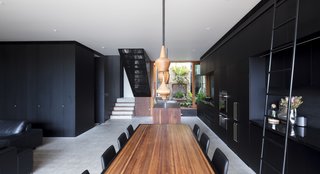 An overview of the first-floor living space. Despite the dark color palette, the home is still able to find plenty of light with the full-height sliding doors.