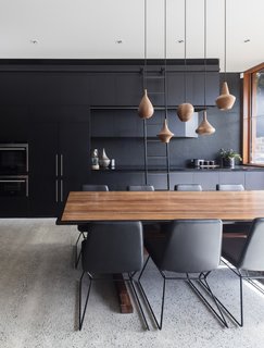 Perforated black panels became a recurring theme throughout the home. For instance, here they are employed on the walls of the kitchen.