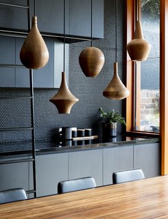 The perforated black walls are juxtaposed against warm wooden details. 