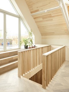 The staircase ascents to the bright and spacious upper level, which features high-vaulted ceilings. 