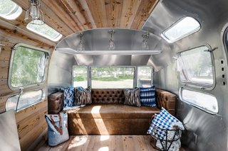 The updated interiors of the airstream are a mix of wood-paneling and the RV's iconic, shiny silver finish. 