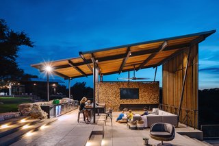 Attached to the pool is a single-pitch, steel-framed pavilion with an outdoor kitchen and dining area. The shelter provides additional outdoor living space for the family to congregate. 