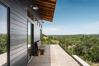 The wraparound deck boasts a view of the surroundings with shade provided by the eaves of the roof. 