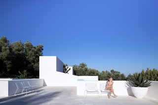 The rectangular edges of the whitewash rooftop terrace is perfectly integrated into the surrounding nature.