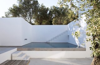The stunning retreat is centered around a serene swimming pool with natural stone touches.