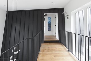 The sloped walls of the original home were integrated and combined with the extension. This was done via the connection of a double-height entry and a second-floor bridge. 